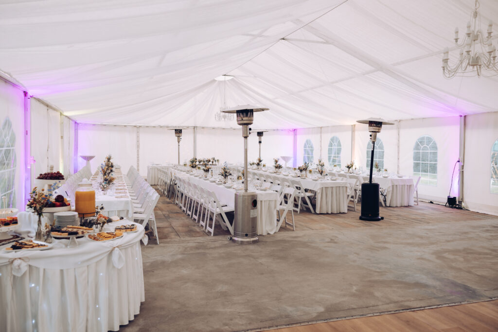 shot of the wedding hall decorated with flowers and lights, tables set with cutlery and beautiful decorations, wedding day